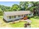 Aerial view of the home highlighting its light gray siding, brown roof, wooden porch and mature trees surrounding the property at 10230 Hagers Rd, Huntersville, NC 28078