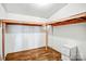 Unfinished basement space with wood-look floors and storage unit at 10230 Hagers Rd, Huntersville, NC 28078