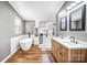 Bright bathroom featuring double vanity, a soaking tub and sleek glass shower at 10230 Hagers Rd, Huntersville, NC 28078