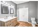 Modern bathroom featuring a double vanity, neutral paint, and wood-look floors at 10230 Hagers Rd, Huntersville, NC 28078