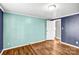 Bright bedroom with wood-look floors, door, and blue and white walls at 10230 Hagers Rd, Huntersville, NC 28078