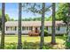 Charming single-story home with neutral siding, dark shutters, a wood porch, a well-manicured lawn and mature trees at 10230 Hagers Rd, Huntersville, NC 28078