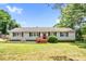 Charming single-story home with wood porch, neutral siding, dark shutters, well-manicured lawn, and mature trees at 10230 Hagers Rd, Huntersville, NC 28078