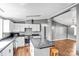 Well-lit kitchen with white cabinetry, stainless steel appliances, hardwood flooring, and a convenient breakfast bar at 10230 Hagers Rd, Huntersville, NC 28078