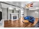 Inviting living room features a white fireplace, hardwood flooring, comfortable blue sofas, and a rustic wood coffee table at 10230 Hagers Rd, Huntersville, NC 28078