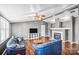 Inviting living room featuring a fireplace, ceiling fan, and hardwood floors with modern touches and plenty of natural light at 10230 Hagers Rd, Huntersville, NC 28078