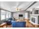 Bright living room featuring hardwood floors, blue sofas, a modern television, and a cozy fireplace with neutral paint at 10230 Hagers Rd, Huntersville, NC 28078