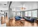 Spacious living room featuring hardwood floors, blue sofas, and an open layout with access to the kitchen and entryway at 10230 Hagers Rd, Huntersville, NC 28078
