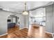 Open-concept space with wood floors, kitchen with island seating, and living area featuring a fireplace and arched doorways at 10230 Hagers Rd, Huntersville, NC 28078
