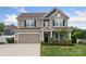 Charming two-story home with a well-manicured lawn, attached garage, and inviting front porch at 108 Wrangler Dr, Mooresville, NC 28115