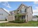 Beautiful two-story home with a well-manicured lawn, attached garage, and inviting front porch at 108 Wrangler Dr, Mooresville, NC 28115