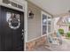 Cozy front porch featuring rocking chairs, stone accents, and a decorative wreath on the black front door at 108 Wrangler Dr, Mooresville, NC 28115