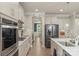 Modern kitchen featuring stainless steel appliances, white cabinetry, and a view into the dining area at 108 Wrangler Dr, Mooresville, NC 28115