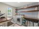 Well-organized laundry room with shelving, stylish wallpaper, and modern machines at 108 Wrangler Dr, Mooresville, NC 28115