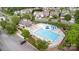 Aerial view showcasing the community pool, play structures, clubhouse, and surrounding greenery at 11014 Aspen Ridge Nw Ln, Concord, NC 28027