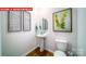 Stylish half bath with modern fixtures, a pedestal sink, and decorative wall art at 11128 Cardinal Creek Ave, Charlotte, NC 28215