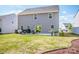 Large backyard features patio with grill, table and chairs, and gray siding at 112 Tanner Loop, Troutman, NC 28166