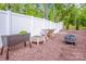 Landscaped backyard with white fence, wood chips, raised planters, and outdoor fire pit at 112 Tanner Loop, Troutman, NC 28166
