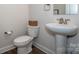 Simple half bathroom with white toilet and pedestal sink at 112 Tanner Loop, Troutman, NC 28166