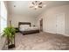 A well lit bedroom with a large bed, ceiling fan and vaulted ceiling, including an ensuite bathroom at 112 Tanner Loop, Troutman, NC 28166