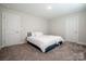 Bedroom with carpet, a bed with white linens between two doors and neutral paint at 112 Tanner Loop, Troutman, NC 28166