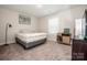 Bedroom featuring a bed, lamp, record player and records with neutral walls and carpet at 112 Tanner Loop, Troutman, NC 28166