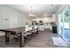 Bright dining area leading into a kitchen with stainless steel appliances and gray wood flooring at 112 Tanner Loop, Troutman, NC 28166