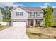 Charming two-story home with gray siding, a two-car garage, well-manicured lawn and freshly landscaped flowerbeds at 112 Tanner Loop, Troutman, NC 28166