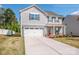 Charming two-story home with gray siding, a two-car garage, well-manicured lawn and freshly landscaped flowerbeds at 112 Tanner Loop, Troutman, NC 28166