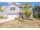 Charming two-story home with gray siding, a two-car garage, well-manicured lawn and freshly landscaped flowerbeds at 112 Tanner Loop, Troutman, NC 28166