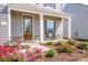 Inviting front porch with neutral decor, attractive landscaping and an updated front door at 112 Tanner Loop, Troutman, NC 28166