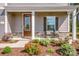 Inviting front porch with neutral decor, attractive landscaping and an updated front door at 112 Tanner Loop, Troutman, NC 28166