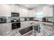 Close up of kitchen with granite countertops, stainless steel appliances, and white cabinets at 112 Tanner Loop, Troutman, NC 28166