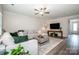 Open-concept living room featuring hardwood floors, a stylish sofa and plenty of natural light at 112 Tanner Loop, Troutman, NC 28166