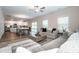 Open-concept living room featuring hardwood floors, a stylish sofa and plenty of natural light at 112 Tanner Loop, Troutman, NC 28166