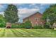 Beautiful brick home featuring a large lawn, mature trees, and manicured landscaping at 1142 Ardwyck Pl # 5, Rock Hill, SC 29730