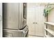 Laundry room with stacked washer and dryer, white shelving, storage cabinets, and double doors at 1142 Ardwyck Pl # 5, Rock Hill, SC 29730