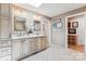 Bright bathroom featuring double sinks, stylish vanity, and a decorative tiled floor at 115 Forestcliff Ne Ct, Concord, NC 28025