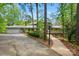 Charming home with a paved driveway, lush landscaping, mature trees, and a covered front entry at 115 Forestcliff Ne Ct, Concord, NC 28025