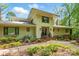 Home exterior with lush landscaping, mature trees, and a welcoming front entryway with a covered porch at 115 Forestcliff Ne Ct, Concord, NC 28025