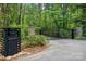Home entrance features an ornate black metal gate with stone pillars, a lamp post, and a neatly maintained driveway at 115 Forestcliff Ne Ct, Concord, NC 28025