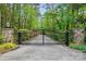 Ornate black metal gate with stone pillars and decorative lamp posts for the entrance to the property at 115 Forestcliff Ne Ct, Concord, NC 28025