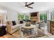 Relax in this cozy living room with stone fireplace and views of the landscaped backyard at 115 Forestcliff Ne Ct, Concord, NC 28025