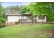 Backyard view of home with a porch and beautiful yard with grass and a forest in the background at 1205 Southwood Dr, Newton, NC 28658
