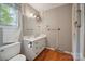 Traditional bathroom with wallpaper, a single sink vanity, and wood flooring at 1205 Southwood Dr, Newton, NC 28658