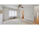 Bedroom with neutral carpeting and paint features a ceiling fan, window, and bathroom access at 1205 Southwood Dr, Newton, NC 28658