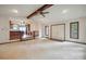 Spacious living room with ceiling beam, view into kitchen, hardwood flooring, and double-door front entry at 1205 Southwood Dr, Newton, NC 28658
