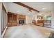 Living room shows ceiling beam, fireplace, and view into adjacent kitchen with hardwood flooring at 1205 Southwood Dr, Newton, NC 28658
