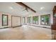 This bright living room shows the front entry, ceiling beam, hardwood floors, and large picture windows at 1205 Southwood Dr, Newton, NC 28658