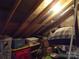 Spacious attic storage area with exposed wood beams, insulation, and organized storage containers at 1502 Mulberry Ridge Dr # 1, Newton, NC 28658